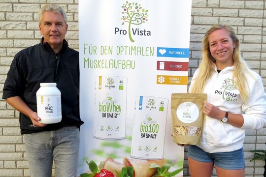 Die Gründer von Pro Vista präsentieren ihrer Marke und Produkte. Im Hintergrund ist ein Werbe-Banner von Pro Vista zu sehen.