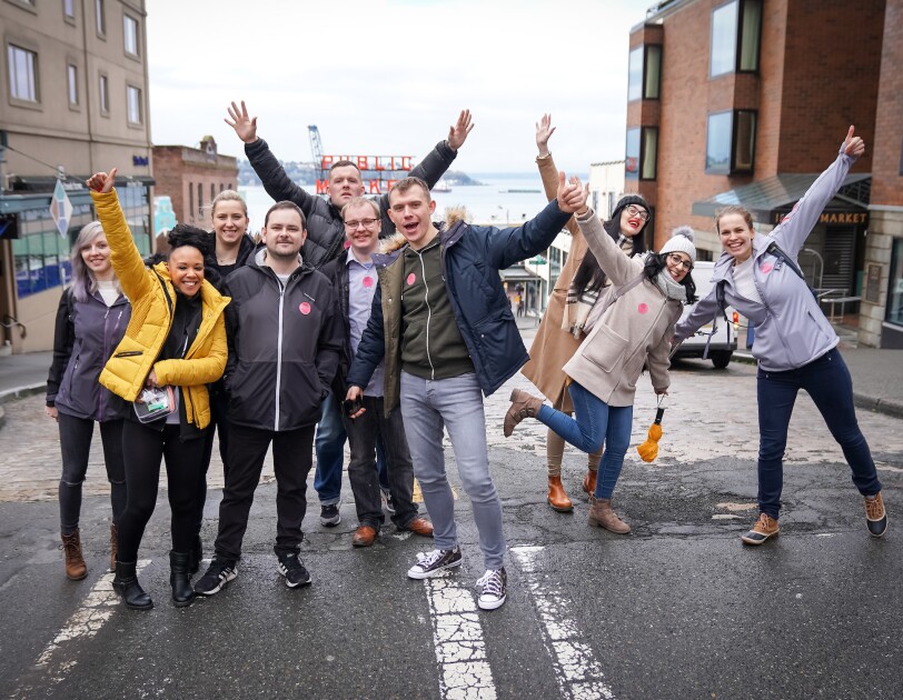 Group shot of Amazon employees on the 'I Found the Right Place' programme in Seattle, they are outside of a market.