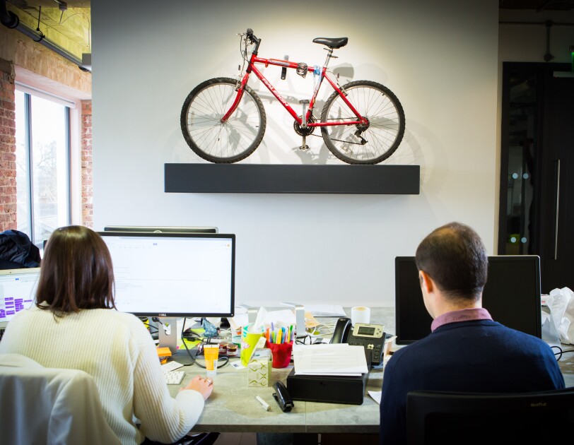 People sat at computers with a small bike in the foreground