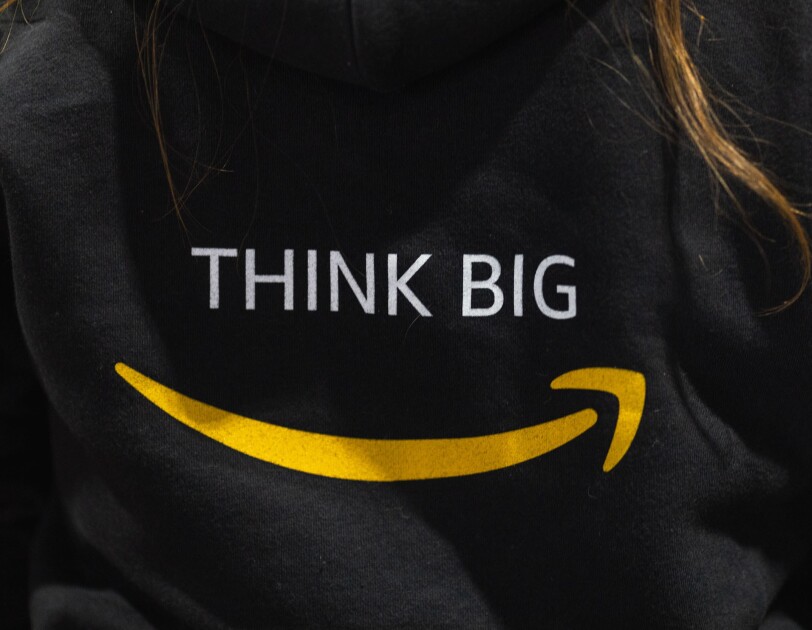 Napis "Think Big" na czarnej koszuli, pod spodem logo Amazon