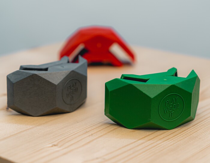 Tre morsetti Playwood in verde, grigio e rosso su una superficie di legno