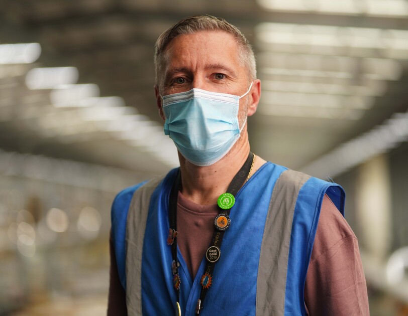Man wearing a mask inside Amazon fulfilment centre