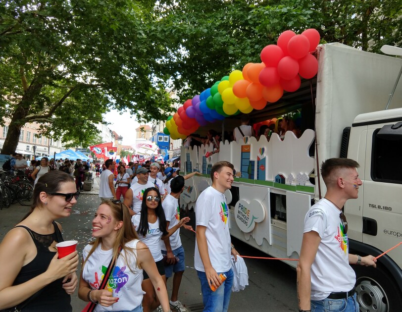 Amazon Mitarbeiter feiern neben dem Glamazon-Wagen auf dem Christopher Street Day in München.