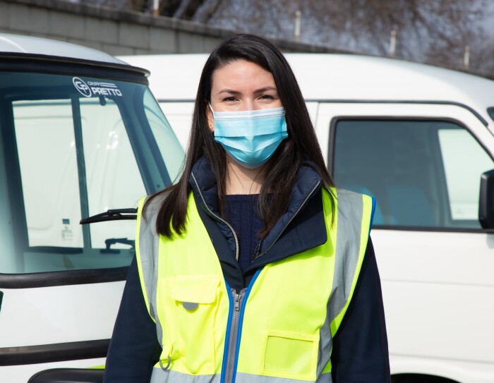 Micaela Moscarella posa davanti ad alcuni veicoli elettrici per le consegne Same Day