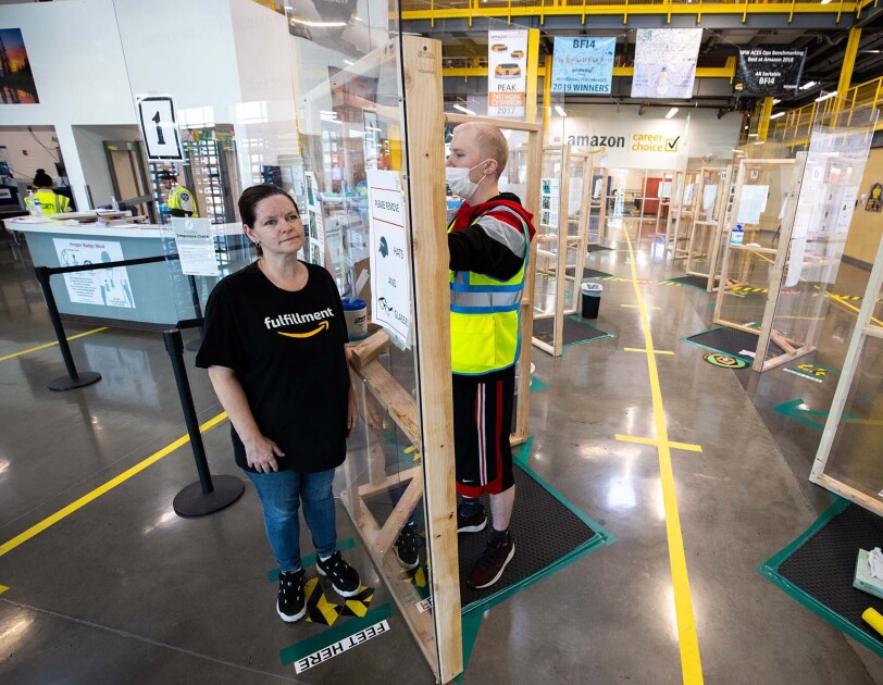 Amazon associate in a fulfillment center following additional safety proceedures in response to the COVID-19 pandemic