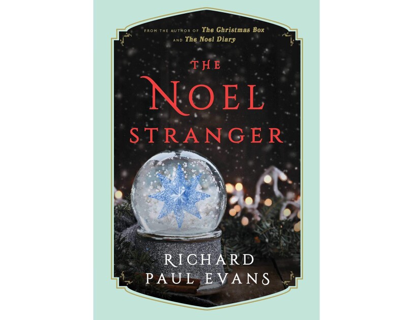Book cover for "The Noel Stranger" shows a snow globe in the foreground with snow falling around a large crystal snowflake. In the background is garland, with Christmas lights, snow falls on the scene. The title is in red, with the author's name in white.