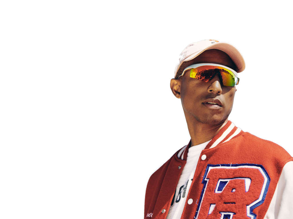 The artist Pharrell stands on a white background wearing sunglasses and a hat.
