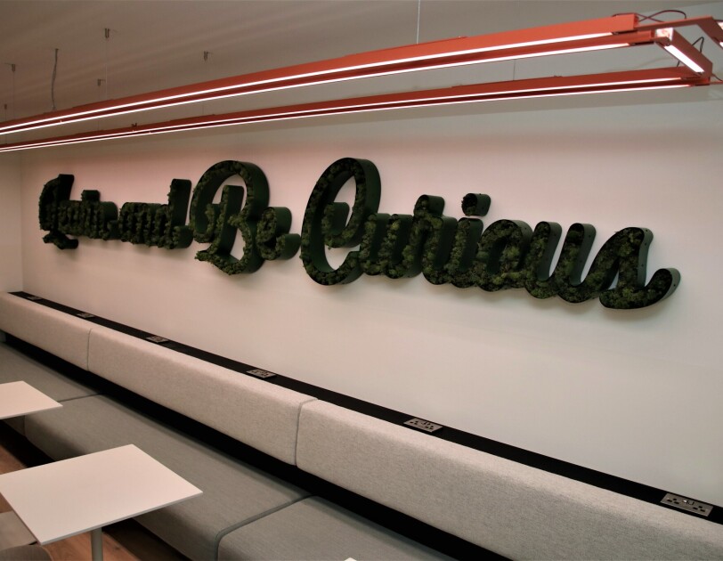 Sign at the Amazon Manchester offices reading "Learn and Be Curious"