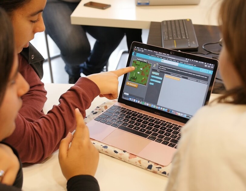 Trois jeunes filles réalisent ensembles un exercice de code sur un ordinateur.