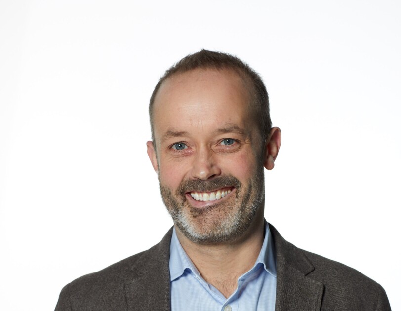 Man in grey jacket smiling at camera